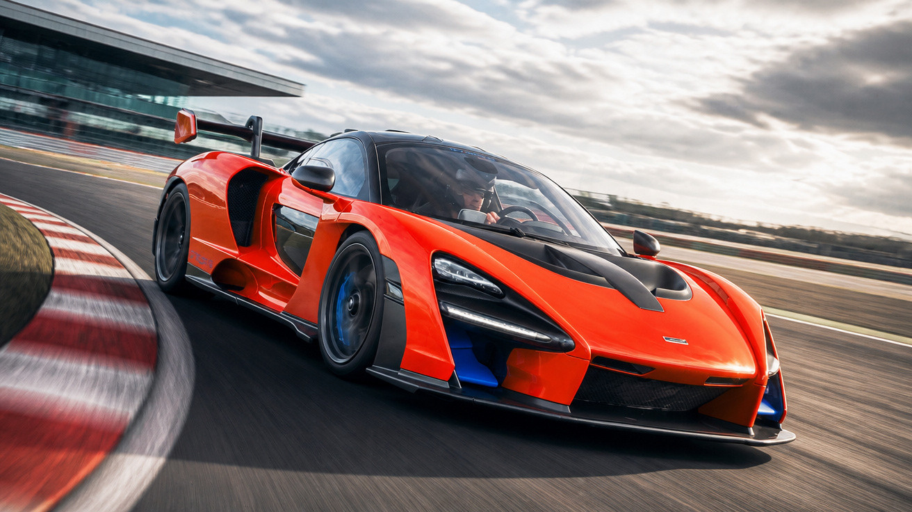 Roter McLaren-Supersportwagen fährt schnell auf Rennstrecke bei bewölktem Himmel.